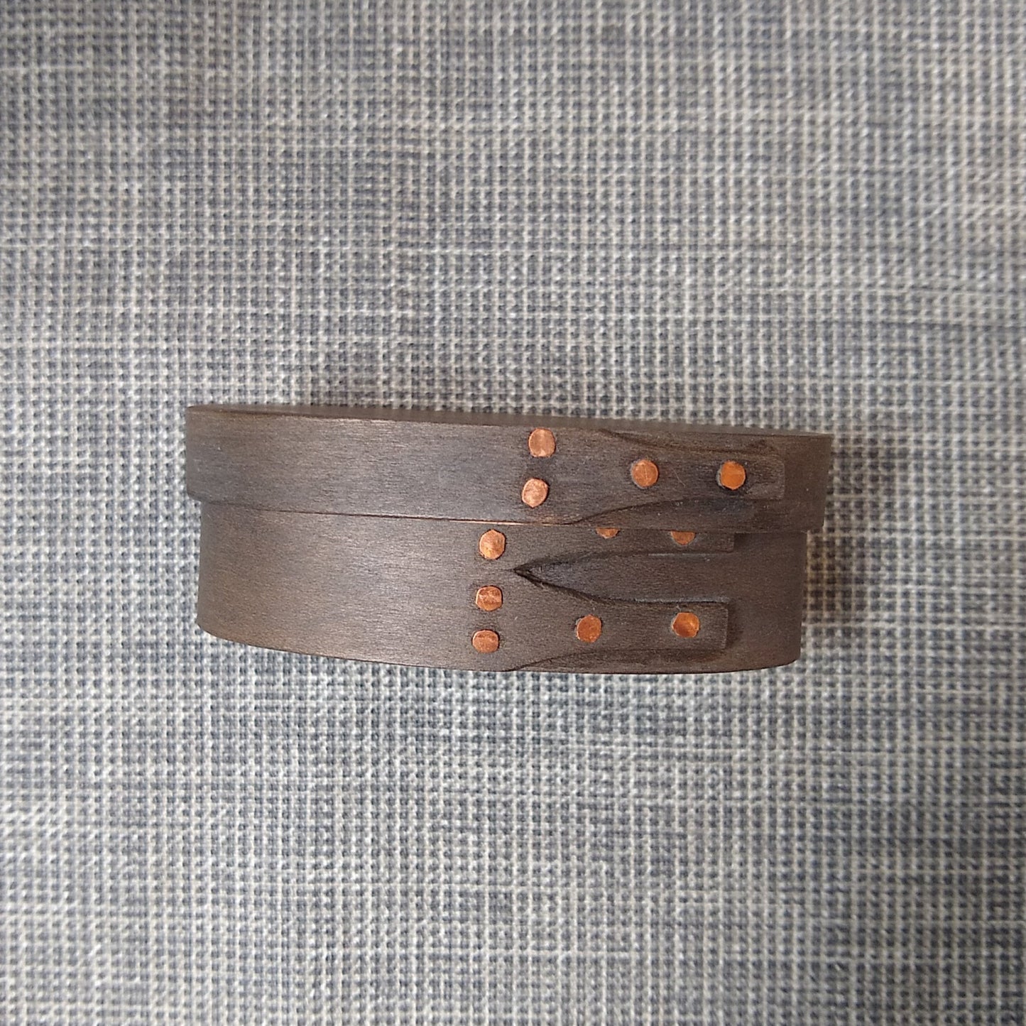 Handmade wooden Shaker oval #00 box with a black/grey outside and a natural maple inside, on a gray tablecloth