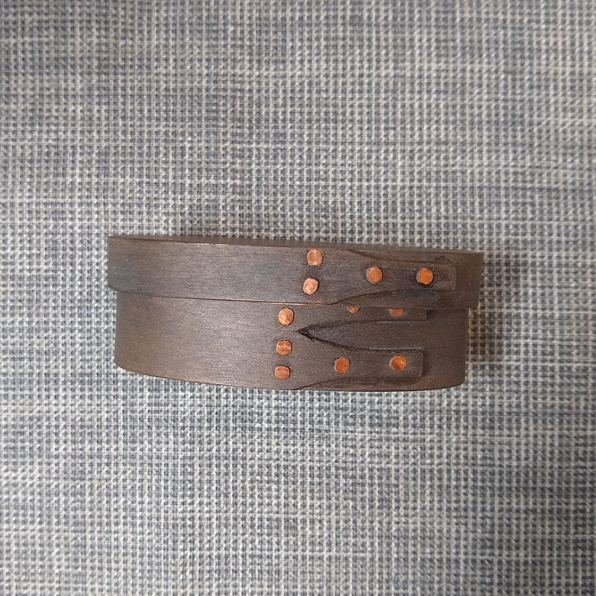 Handmade wooden Shaker oval #00 box with a black/grey outside and a natural maple inside, on a gray tablecloth
